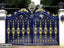 Ornate blue and gold metal boundary gate with decorative floral patterns, outdoor entrance