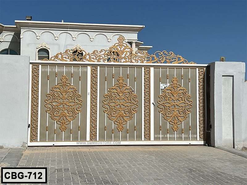 Decorative gold and white metal boundary gate with ornate patterns in front of a modern house