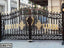 Ornate black and gold metal boundary gate with decorative scrollwork and geometric patterns