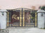 Ornate black and gold metal boundary gate with decorative floral design, outdoor entrance.