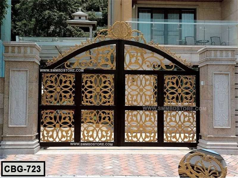 Elegant metal boundary gate with gold ornamental design and stone pillars at villa entrance