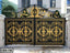 Luxury black and gold wrought iron boundary gate with ornate floral patterns, villa background