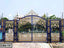 Decorative wrought iron boundary gate with intricate gold patterns, outdoor entrance design