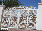 Ornate white and gold decorative metal boundary gate with floral patterns, outdoor setting