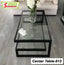 Modern glass coffee table with black metal frame, flower vase, and decorative tray in living room