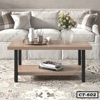 Modern wooden center table with black legs, vase, and tray, in front of a sofa in living room