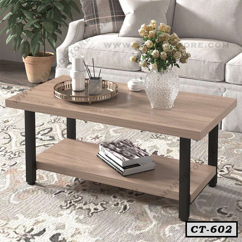 Modern wooden center table with black legs in a living room, decorated with a flower vase and tray.