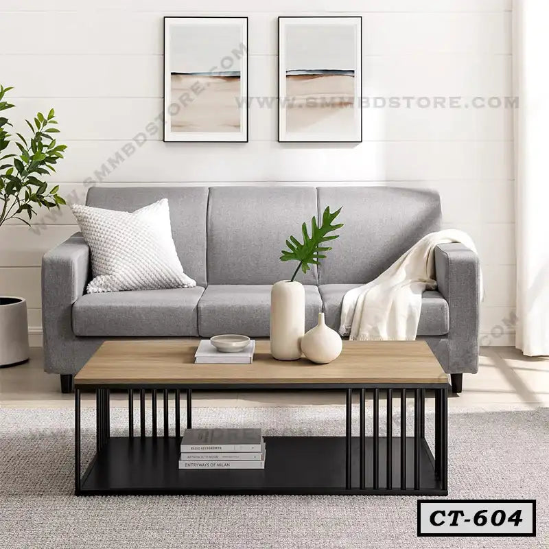 Modern center table with wooden top and black metal frame in a living room with grey sofa.