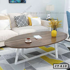 Modern oval wooden center table with white legs in living room, placed on geometric rug