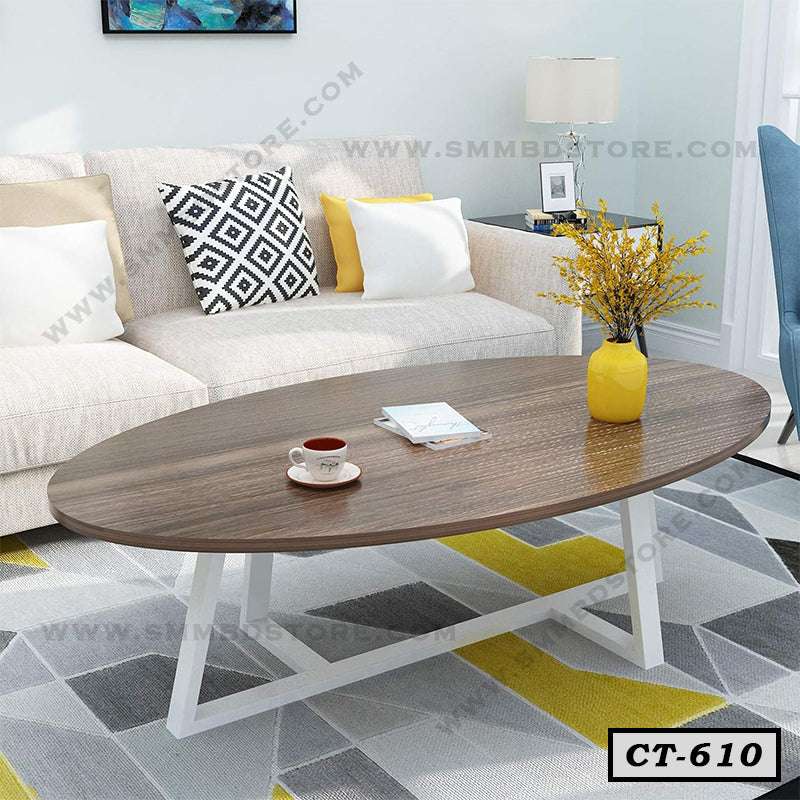 Modern oval wooden center table with white legs in living room, placed on geometric rug