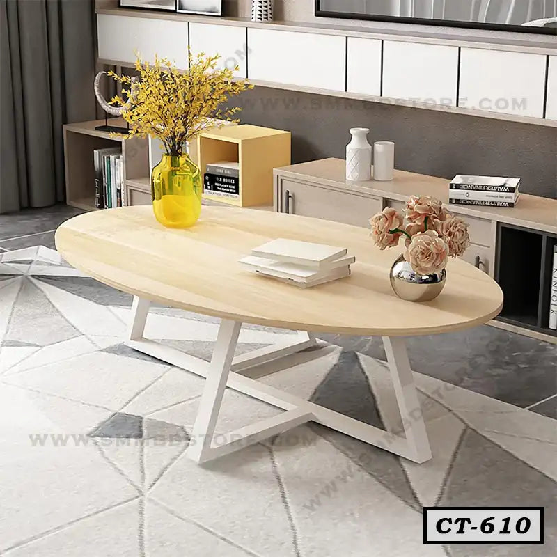 Modern oval wooden center table with white metal legs in a stylish living room setting