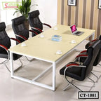 Modern conference table with six black office chairs, laptop, books, and coffee cups in meeting room.