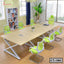 Modern conference room with large wooden meeting table, green mesh chairs and city view window