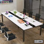 Modern white conference table with laptops, chairs, and office folders in a meeting room