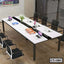 Modern white conference table with laptops, chairs, and office folders in a meeting room