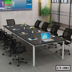 Modern conference room with black table, mesh office chairs, laptops, and decorative plants