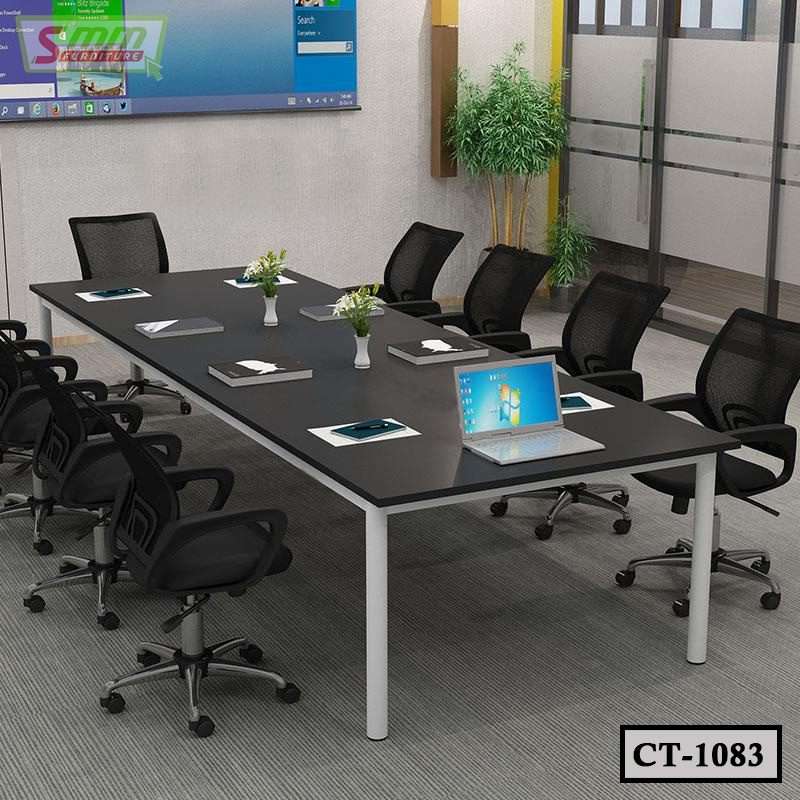 Modern conference room with black table, mesh office chairs, laptops, and decorative plants