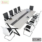 Modern conference table with eight black and white chairs, laptop and book on tabletop