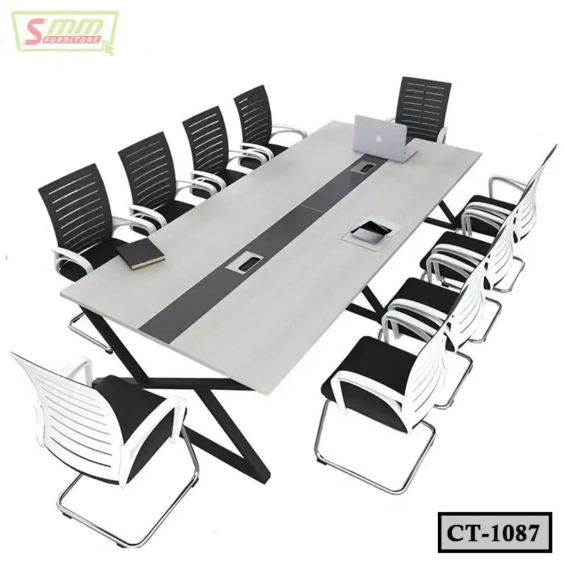 Modern conference table with eight black and white chairs, laptop and book on tabletop