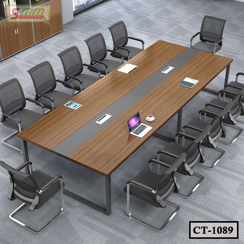 Modern conference room with a large rectangular wooden meeting table and mesh chairs