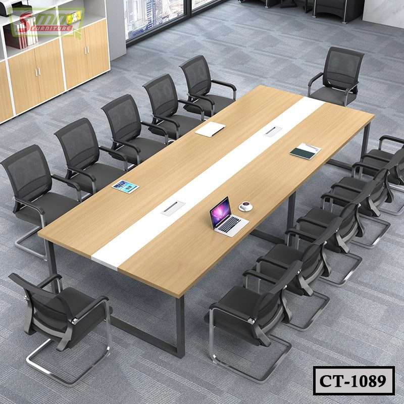 Modern conference room with large rectangular meeting table, black office chairs, and devices