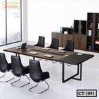 Modern conference table with six black chairs, laptops, and office cabinets in meeting room