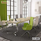 Modern conference table with green and white chairs in bright meeting room