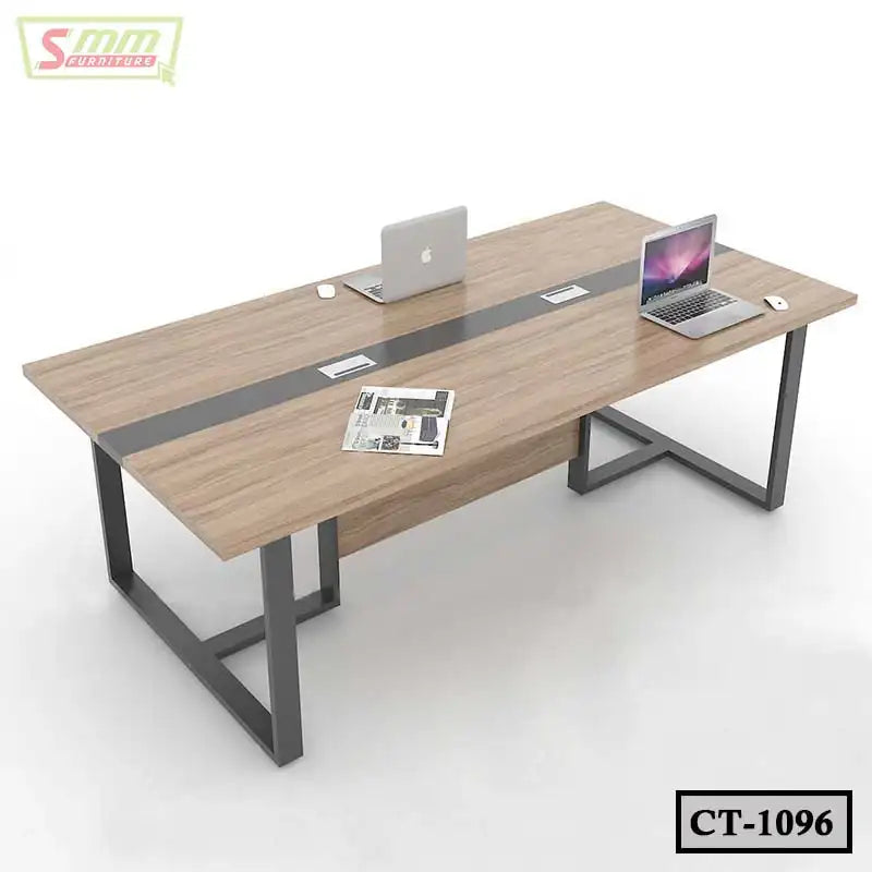 Modern conference table with metal legs, wood finish, built-in cable management, laptops and a newspaper on top. Main image