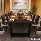 Modern conference table with black and wood finish, surrounded by office chairs in meeting room
