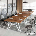 Modern wooden conference table with black office chairs in a meeting room setup