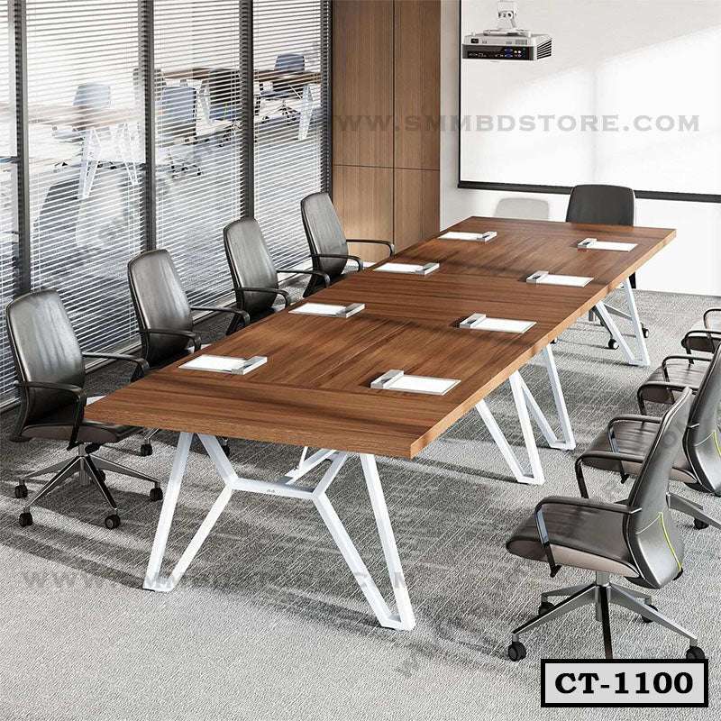 Modern wooden conference table with black office chairs in a meeting room setup