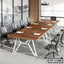 Modern wooden conference table with black office chairs in a meeting room setup