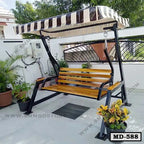 Outdoor patio swing chair with striped canopy and wooden slats, placed on a terrace