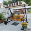 Outdoor patio swing chair with striped canopy and wooden slats, placed on a terrace