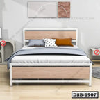 Modern double steel bed with wooden panels, pillows, and bedding in a minimalist bedroom.