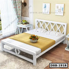Modern white double steel bed with gold bedsheet in a bright bedroom with floral decor