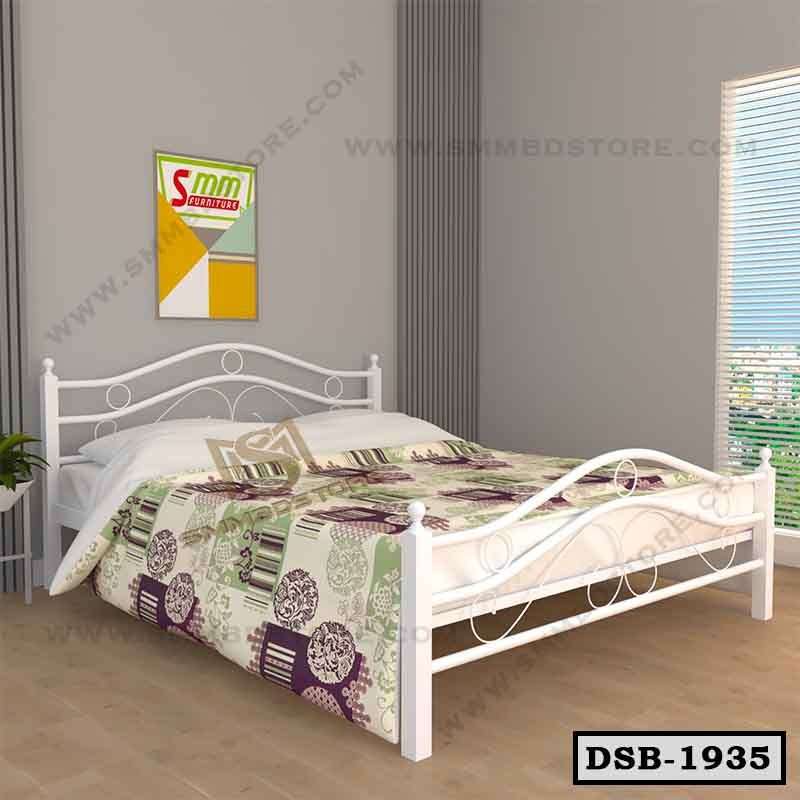 Modern double steel bed with white frame, colorful bedding, in a bright bedroom