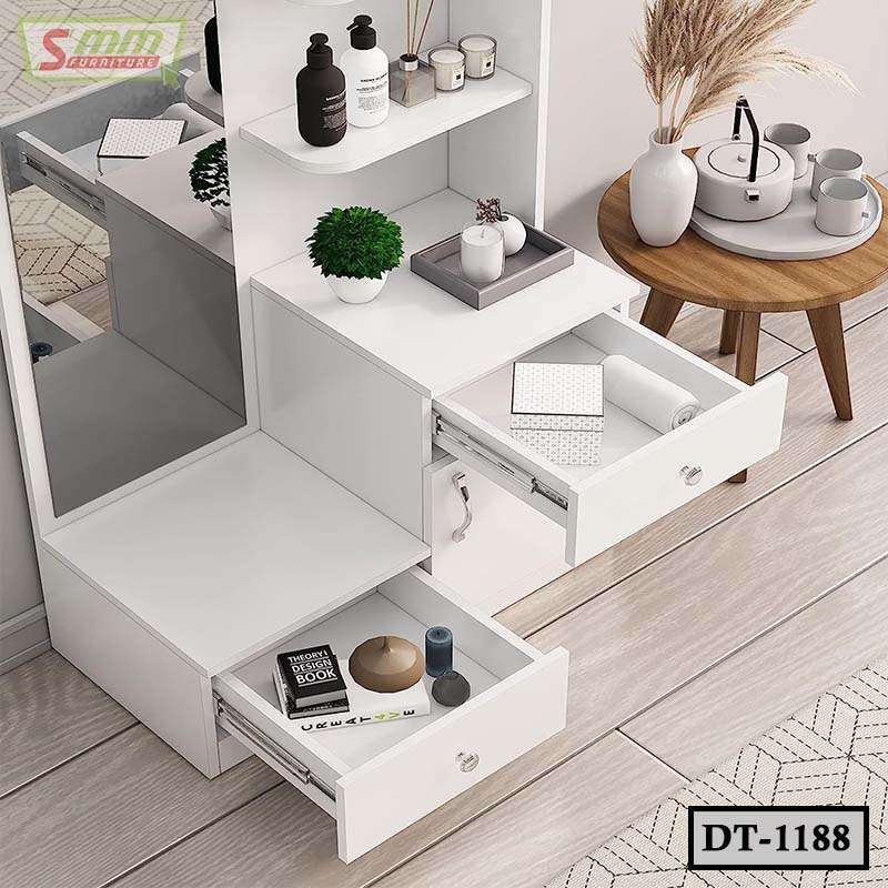 Modern white dressing table with open drawers, mirror, plants, and decorative accessories.