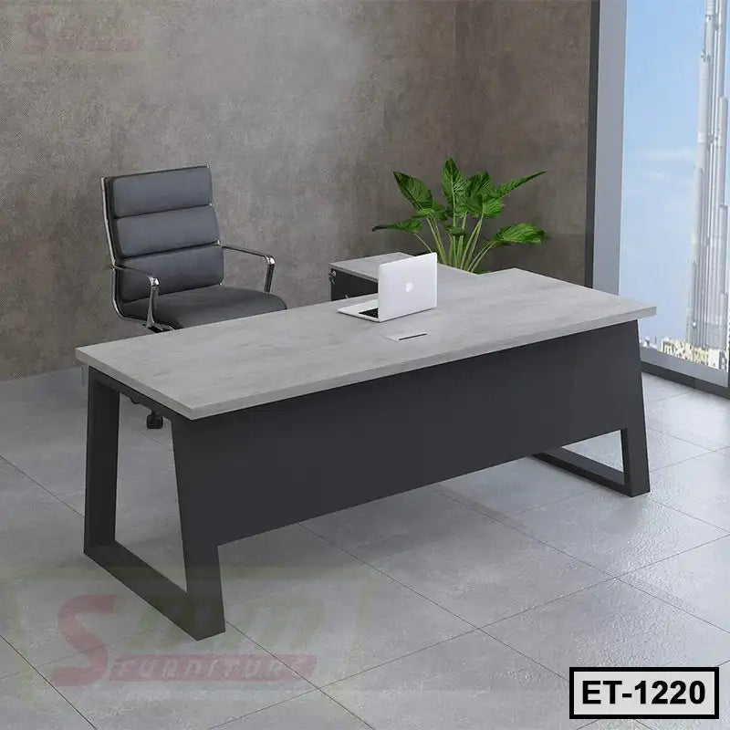 Modern executive office table with grey tabletop, black frame, office chair, and indoor plant
