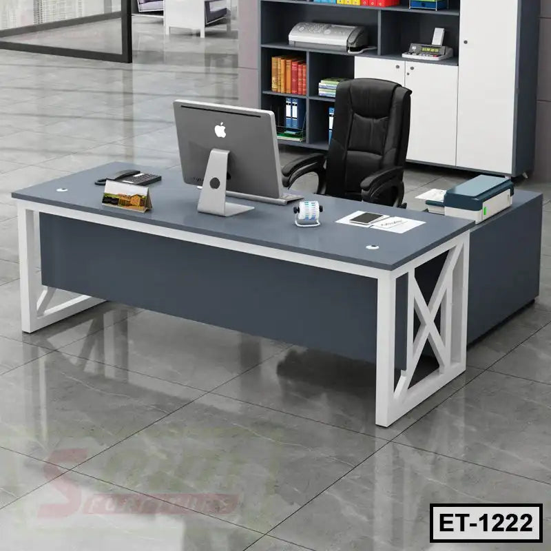 Modern executive office table with black chair, desktop computer, and office storage shelves