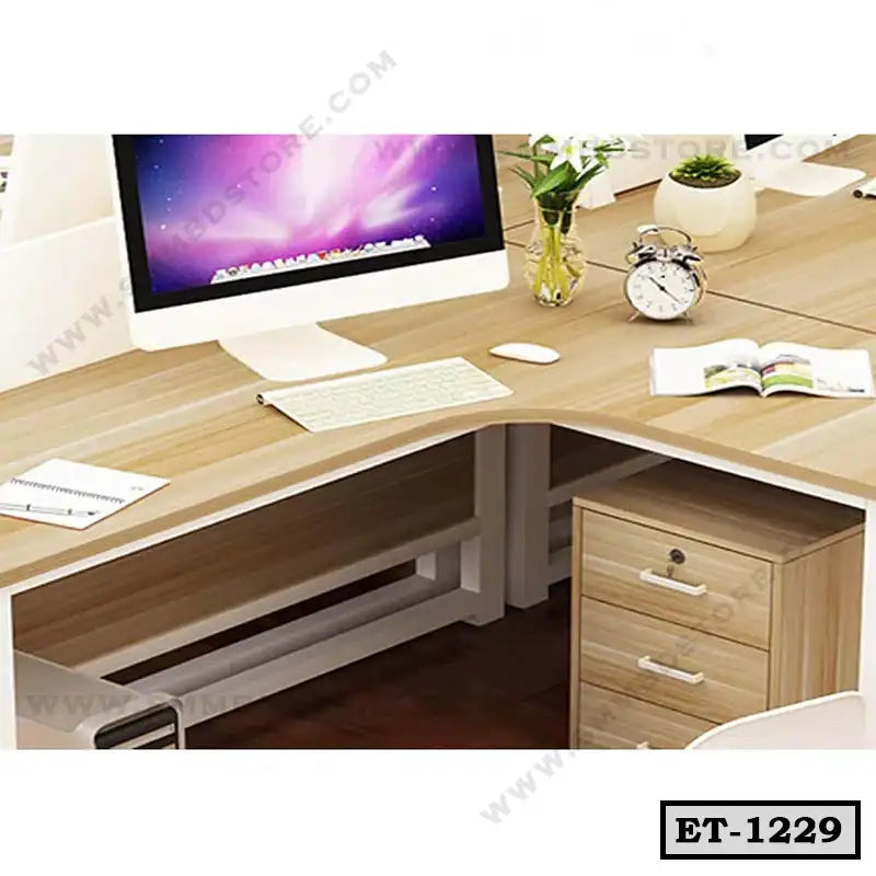 Modern executive office table with wooden finish, drawers, desktop computer, and decor items