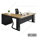 Modern executive office table with wooden top, black metal frame, mesh chair, laptop, and decor