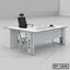 Modern executive office table with white surface, black office chair, and workspace accessories