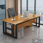 Modern executive office table with wooden top, black metal frame, and office chair in a high-rise office.