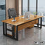 Modern executive office table with wooden top, black metal frame, and office chair in a high-rise office.