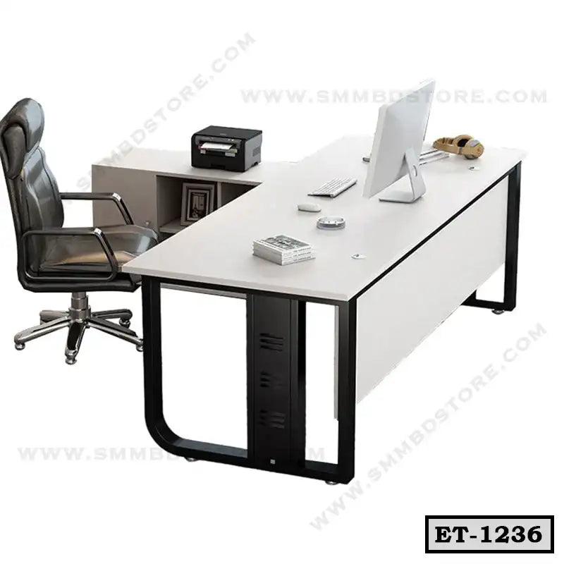 Modern executive office table with L-shaped desk, black chair, and computer setup