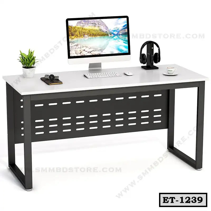 Modern executive office table with computer, headphones, plant, and accessories.