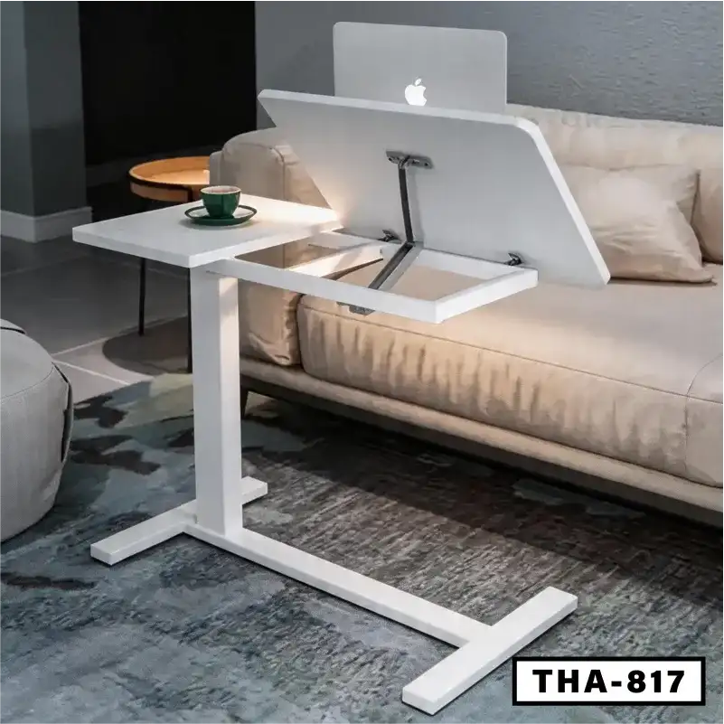 White folding laptop desk with adjustable top beside a beige sofa in a modern living room