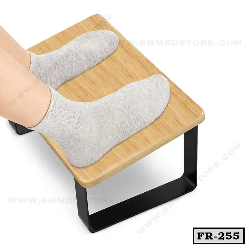 Wooden ergonomic foot rest with black metal legs, shown with feet in socks resting on it Main image