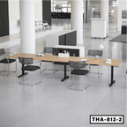 Modern height-adjustable conference table with black frame and mesh office chairs in a bright workspace.